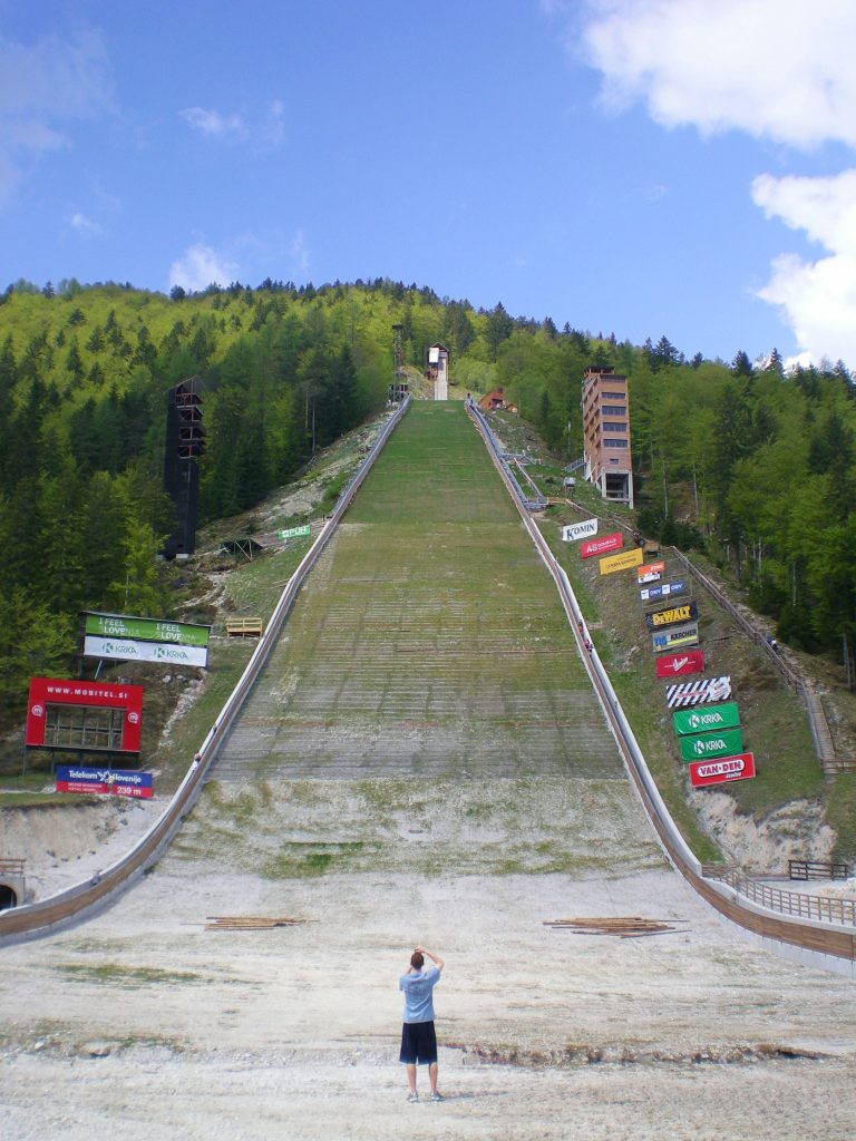 A man standing at the bottom of the Planica ski jump 