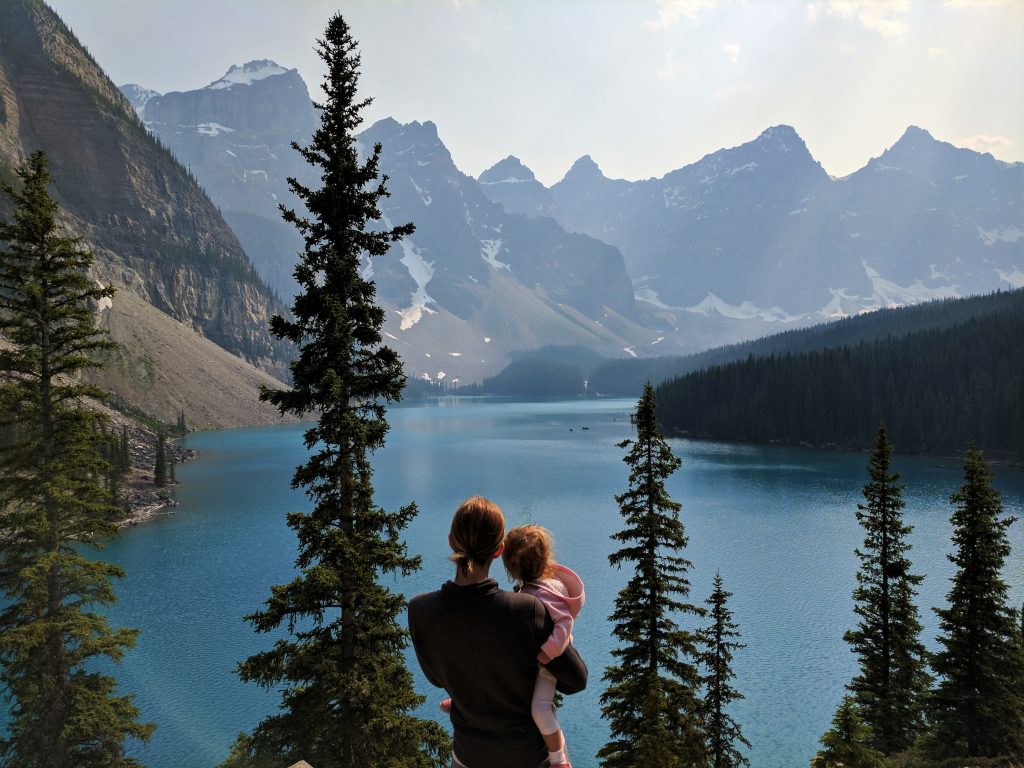 A woman holding a child overlooking Moraine Lake