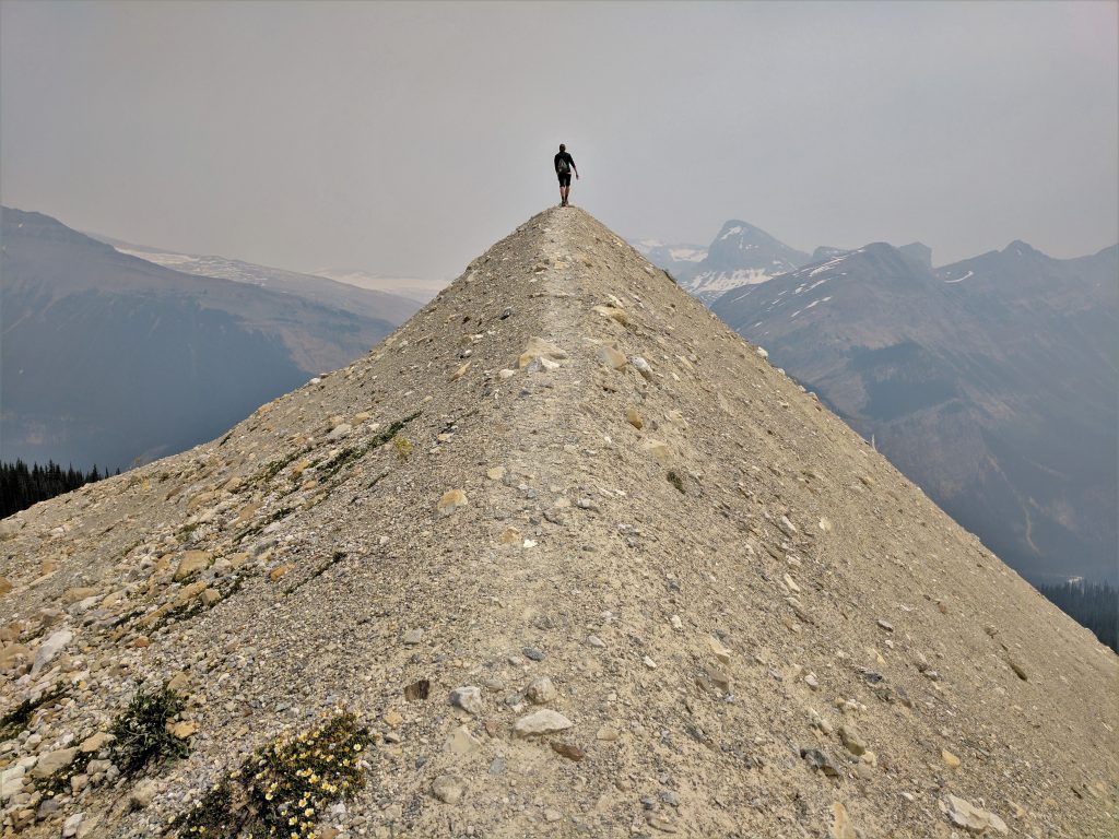 A hiker at the pinnacle of a peak in the Canadian Rockies