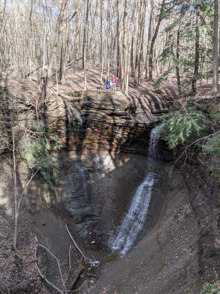 A family surrounded by trees standing at the edge of Linda Falls