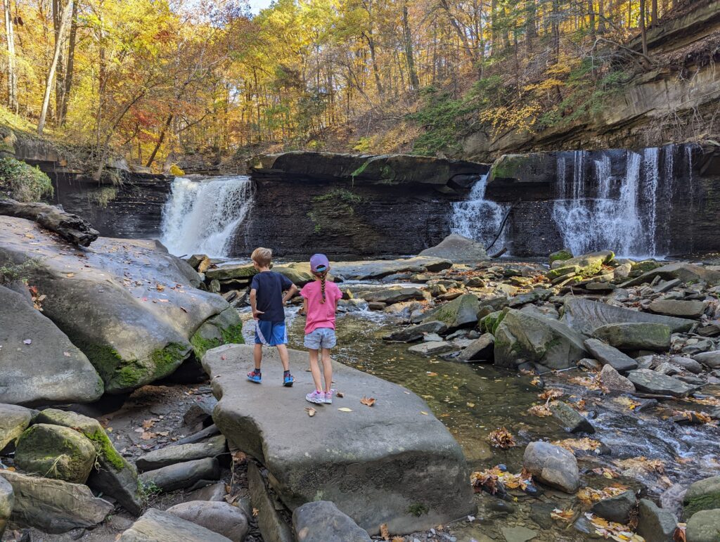 Young kids on rocks at the bottom of the Tinker's Creek waterfall