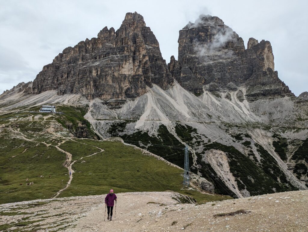 A hiker walking away from Tre Cime in the Dolomites