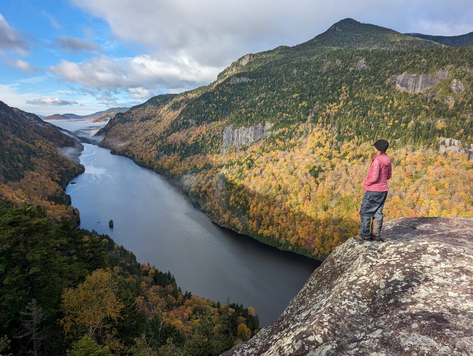 A hiker standing on the edge of Fish Hawk Cliffs in the Adirondacks