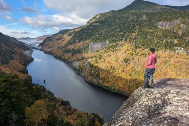 A hiker standing on the edge of Fish Hawk Cliffs in the Adirondacks