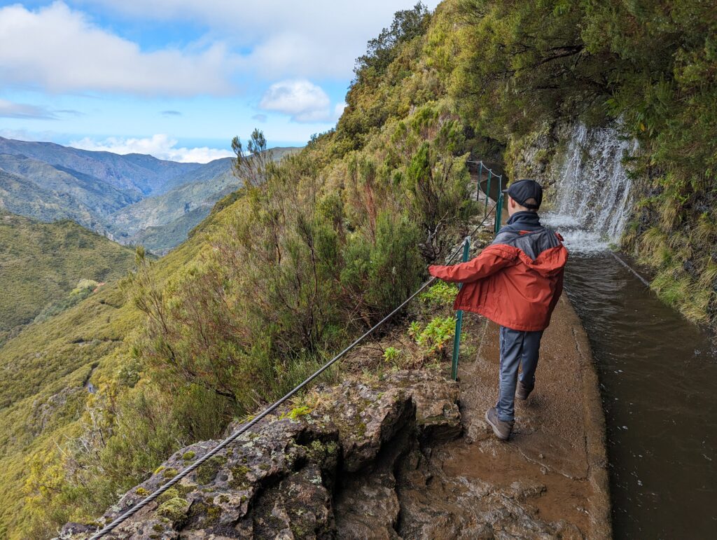 A boy overlooking an open valley along the Levada do Alecrim trail on Madeira