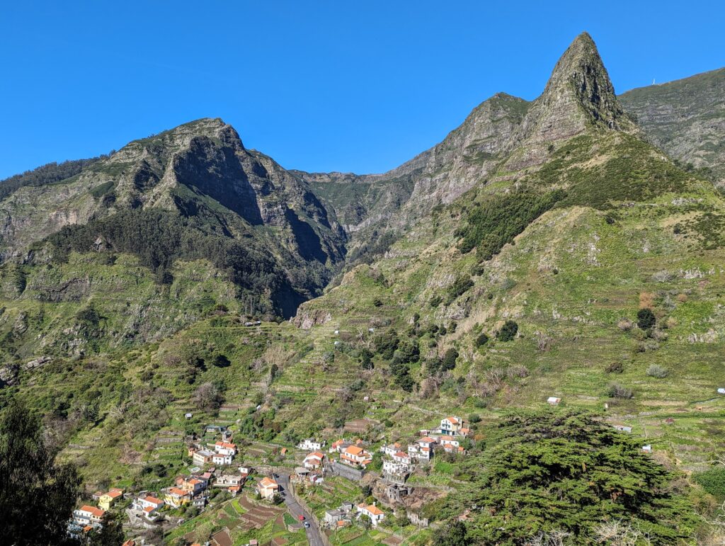 Houses below striking mountains at Pica da Murta on Madeira