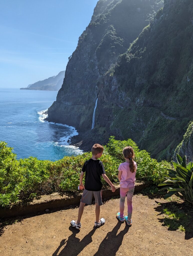 Two young children standing at the Miradouro do Veu da Noiva overlook on Madeira