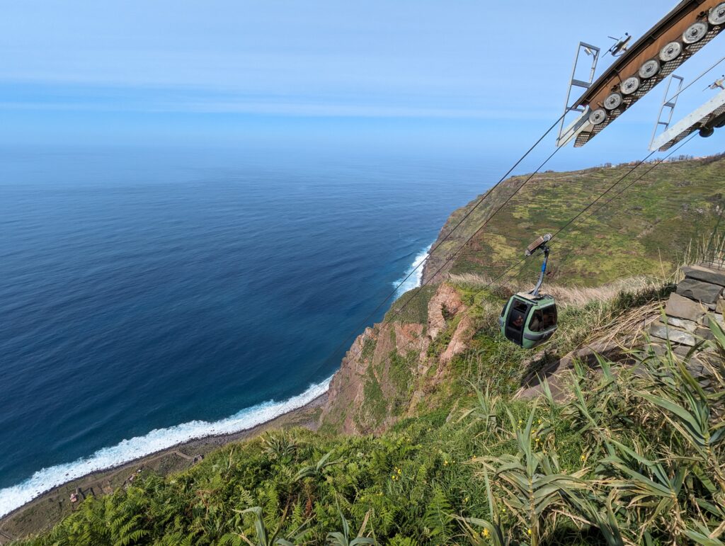 A cable car descending sharply at Achadas da Cruz, with the sea in the background