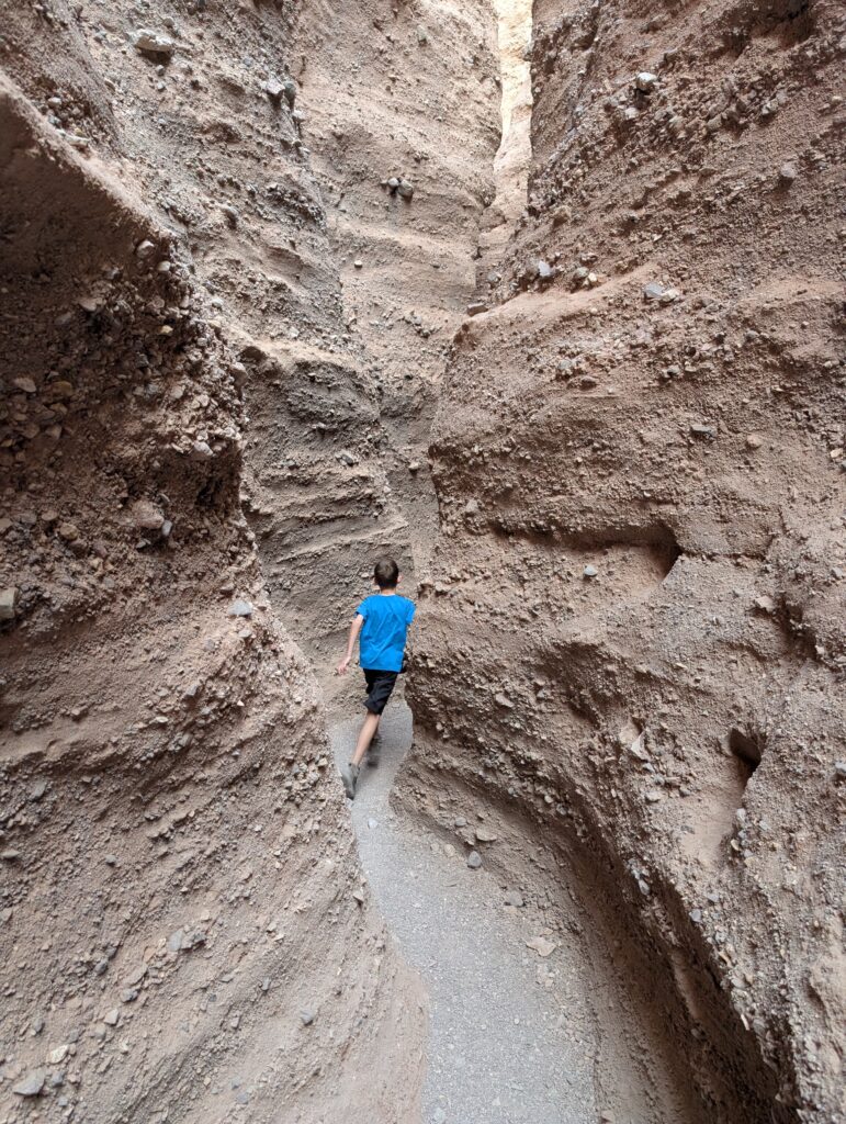 A young boy racing through a slot canyon