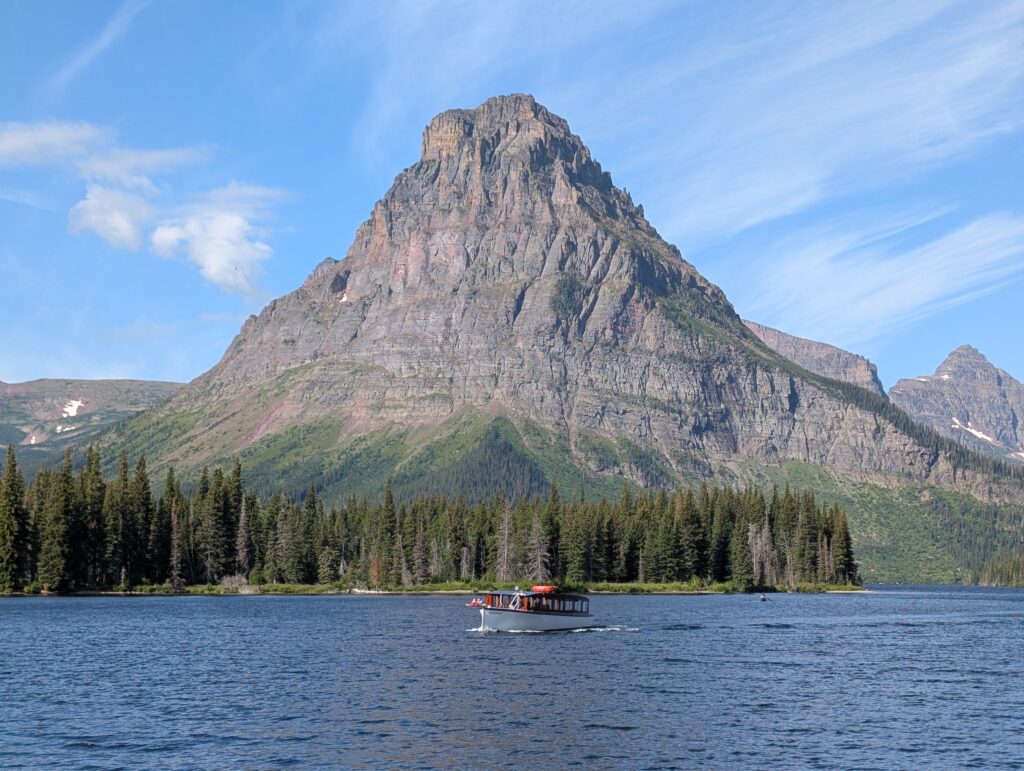 A boat passing in front of Sinopah Mountain at Two Medicine Lake