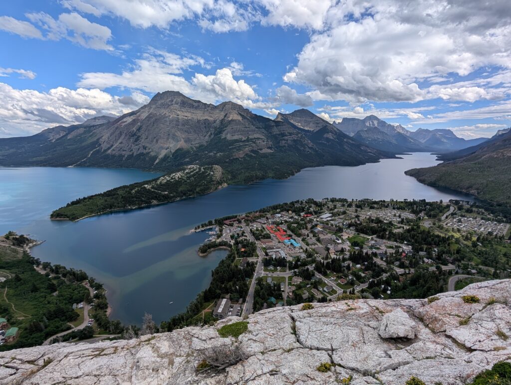 A town on the edge of water and the surrounding mountains in Waterton National Park