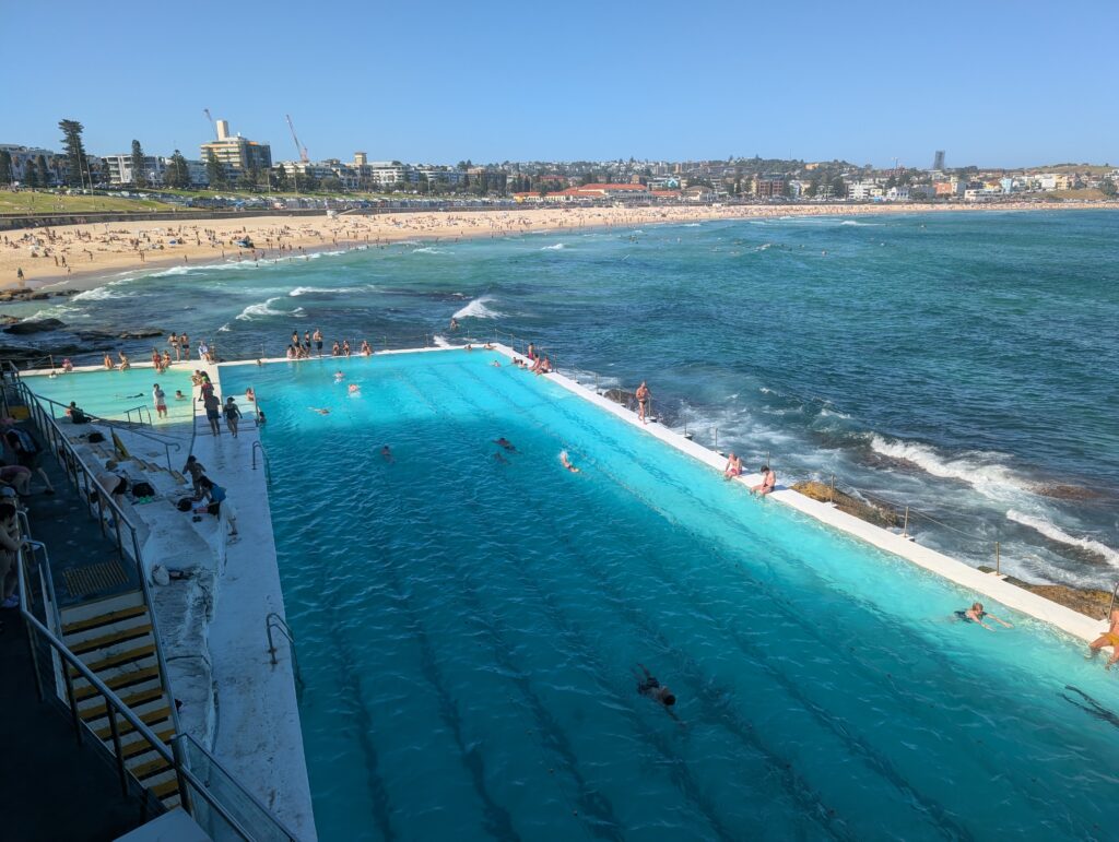 A pool right by the ocean with Bondi Beach in the background
