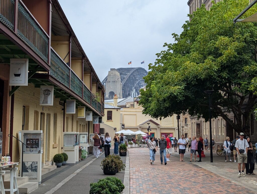 Pedestrians walking down a street lined with shops 
