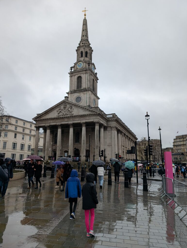 A tall building with columns and a spire in Trafalgar Square