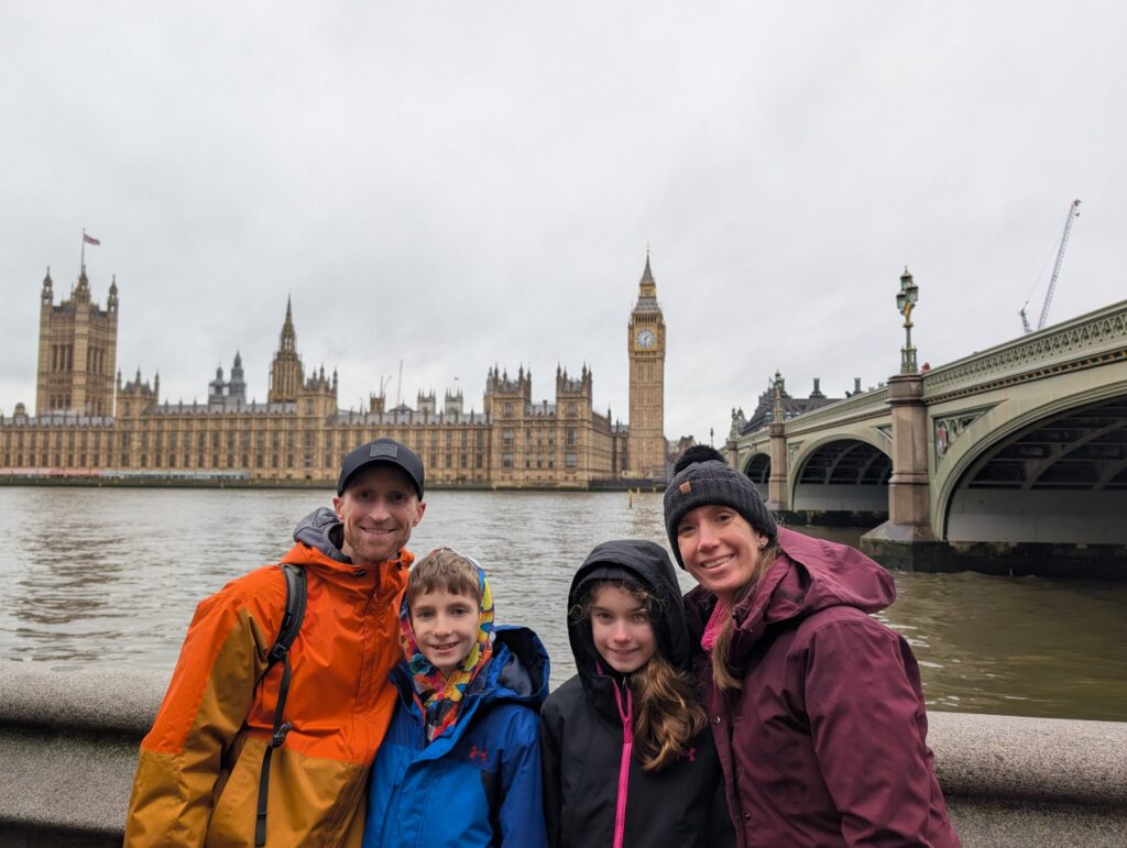 A family of four with a bridge and buildings behind them in London