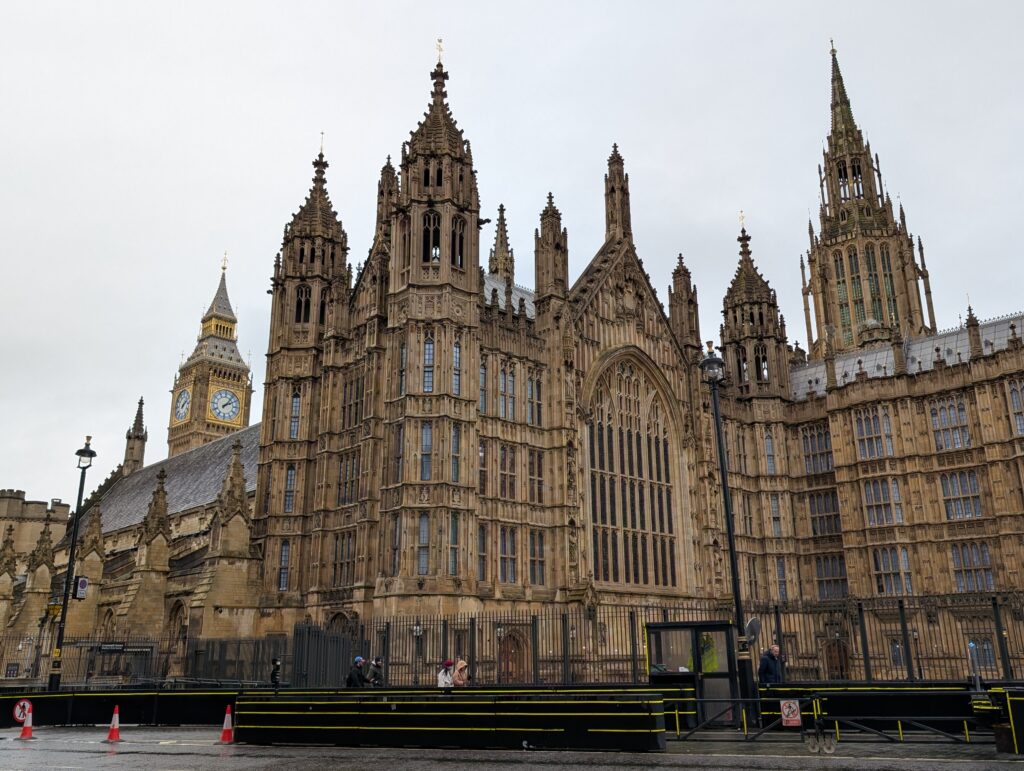 Many spires of the Palace of Westminster jutting into the sky with Big Ben in the background