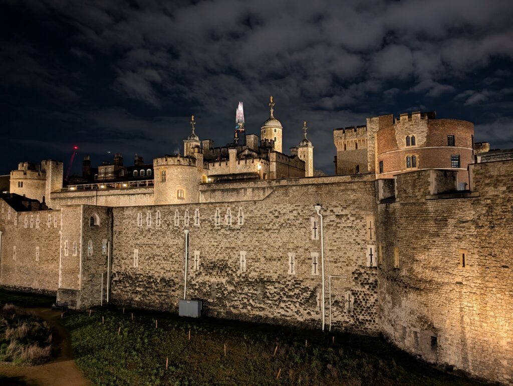 The stone walls of the Tower of London lit up at night