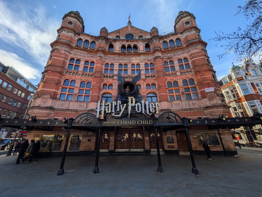 A large building with many windows that has a Harry Potter billboard in front of it
