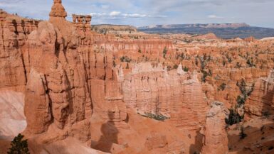 A skinny orange rock formation sticking up above the skyline with many others below it