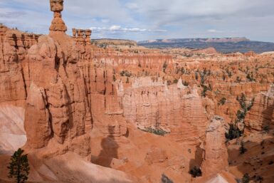 A skinny orange rock formation sticking up above the skyline with many others below it