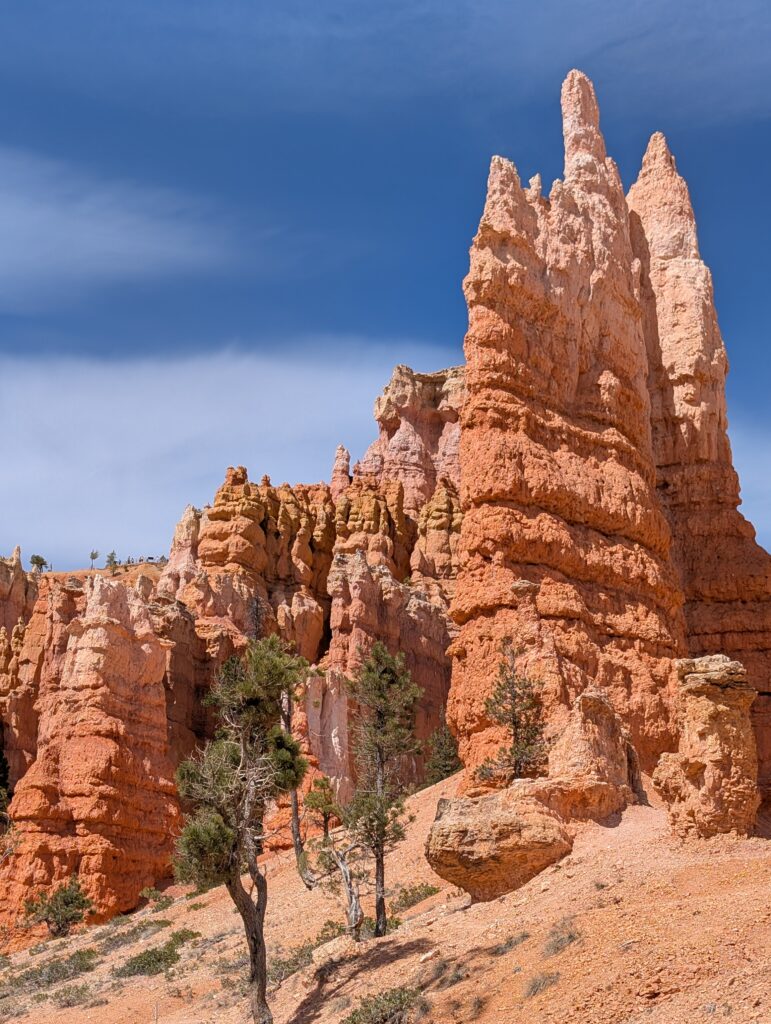 A towering rock formation that turns from orange at the bottom to white at the top