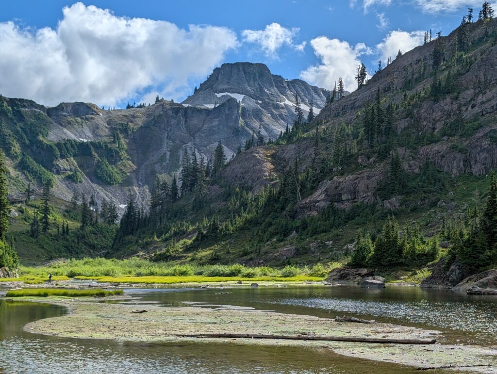 A square-top mountain rising above a body of water with a shaded rocky forest near Artist Point, Washington