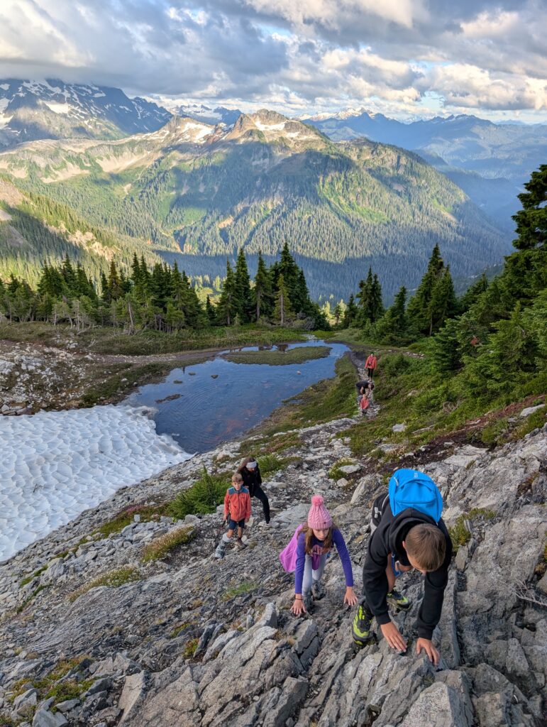 Children climbing up a a rocky landscape with mountains in the background