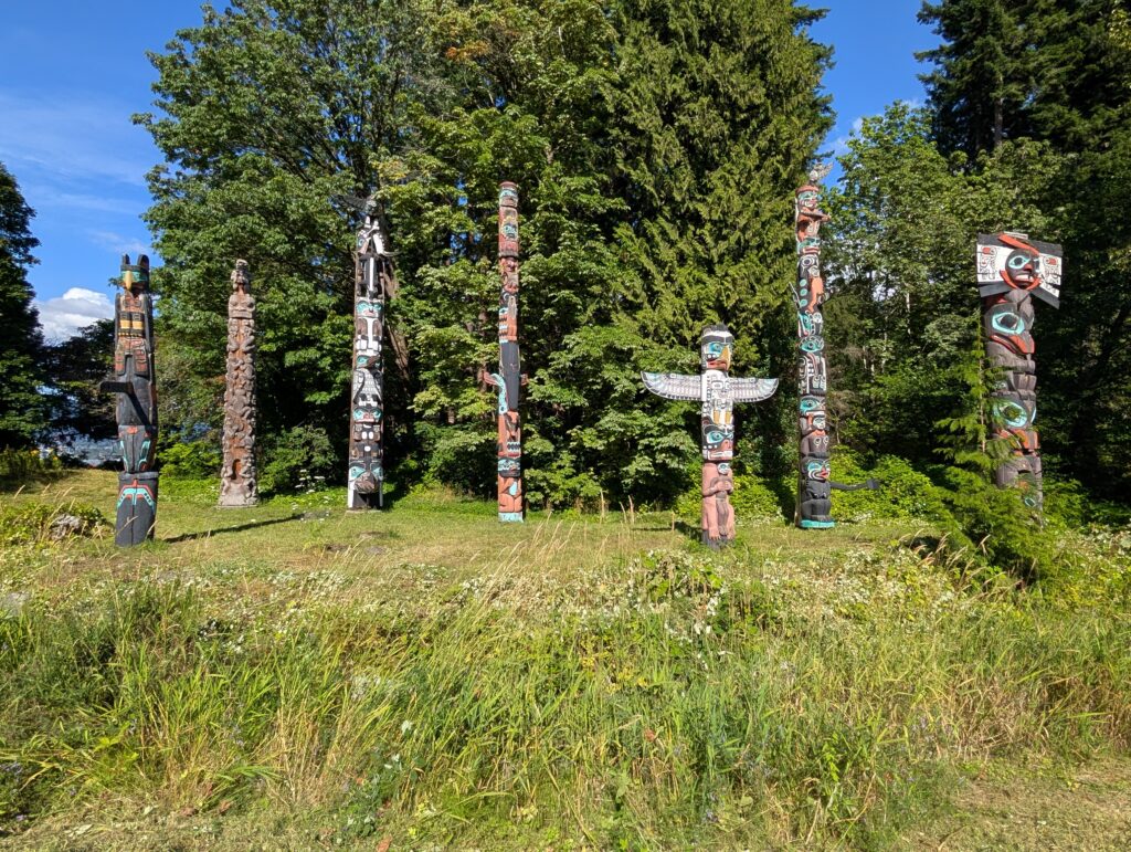 Colorful totem poles surrounded by trees in Stanley Park