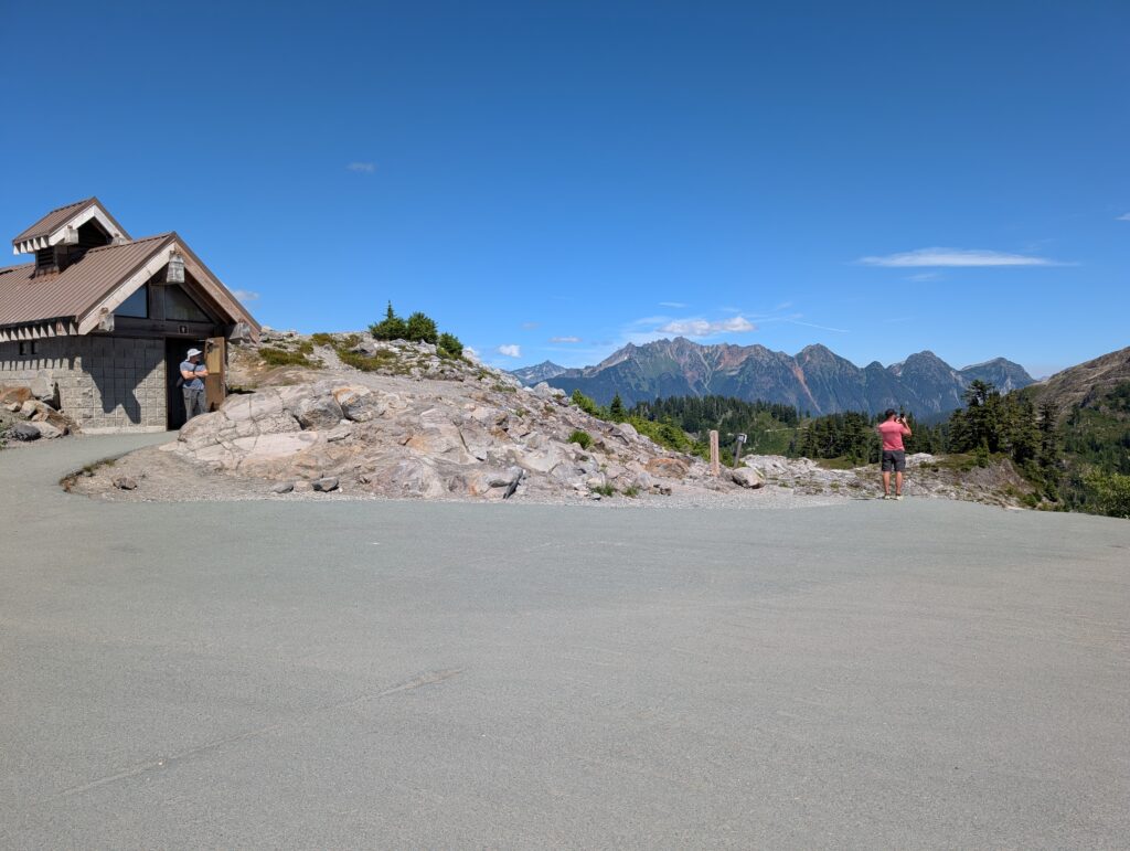 A parking lot with a small structure and far-off mountains